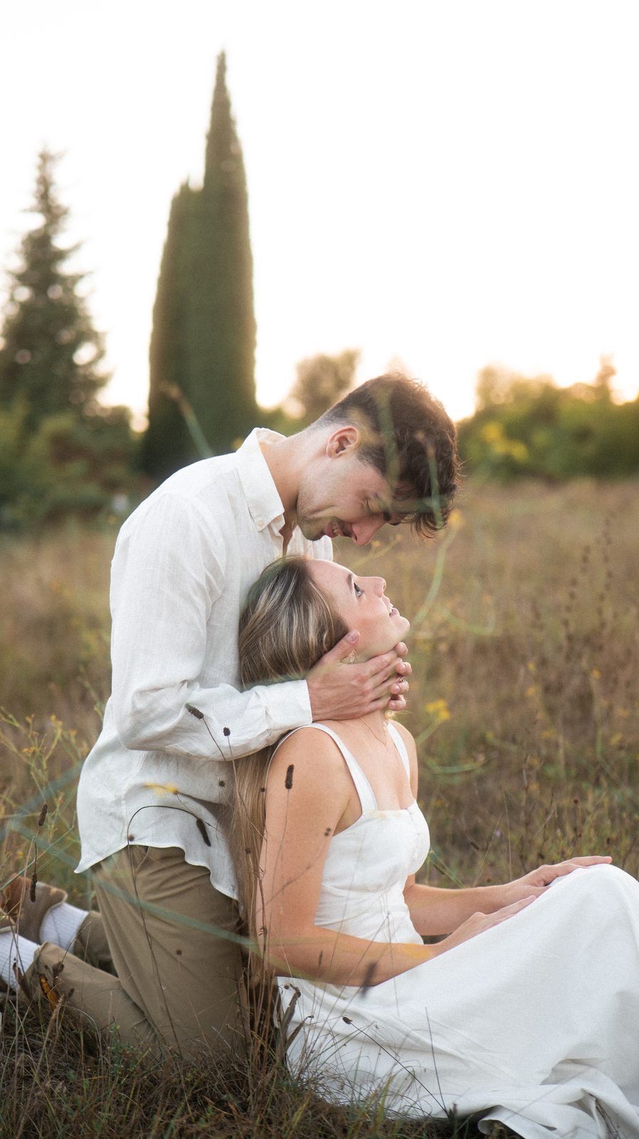 Benjamin embrassant le front de Manon, assis dans l'herbe.